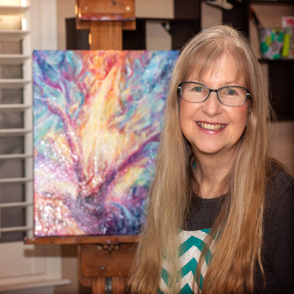 Pamela Pachmayr, artist, at Pachmayr Studios, with her painting "Soul On Fire" in the background